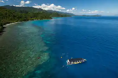 an aerial view of the reef boat moored over the coral with snorkellers spread around it