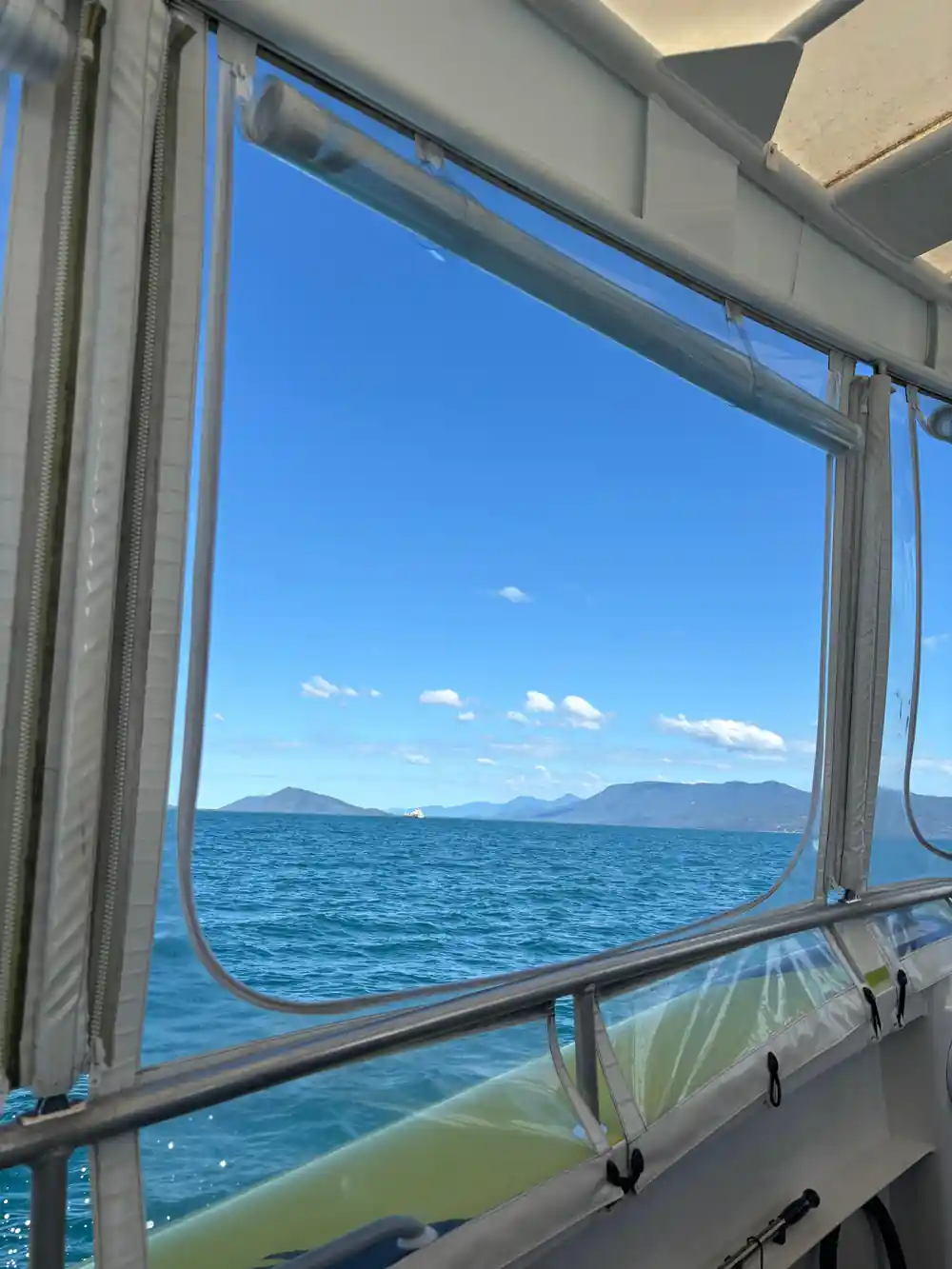 the coastline seen through the open window of the boat cabin